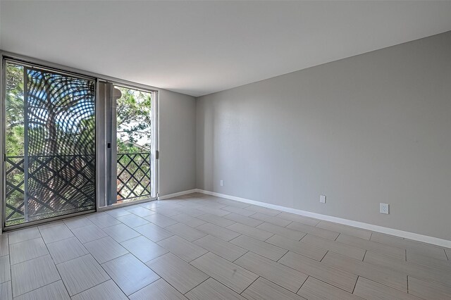 unfurnished room featuring a wall of windows