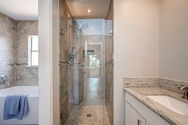 bathroom featuring vanity and independent shower and bath