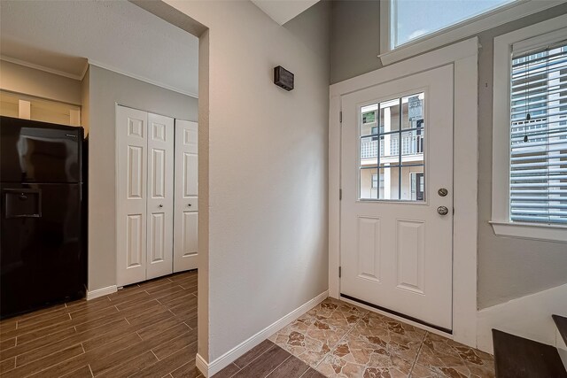 doorway featuring crown molding and a healthy amount of sunlight