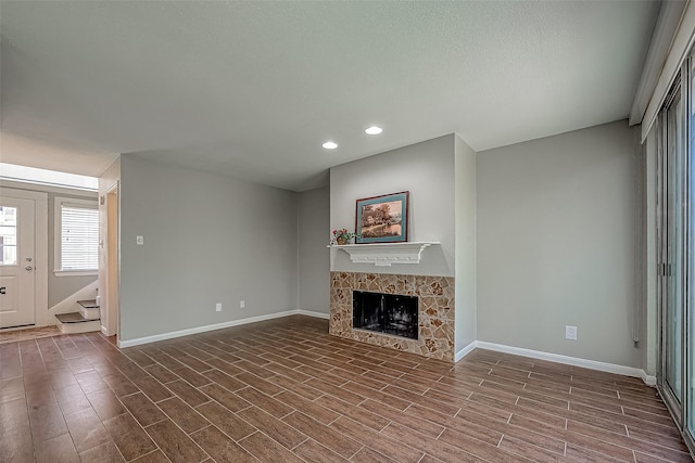 2333 Bering Dr Unit 139, Houston, TX 77057 - unfurnished living room with baseboards, stairway, recessed lighting, a fireplace, and wood finished floors