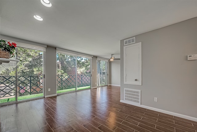 unfurnished room with a brick fireplace and ceiling fan