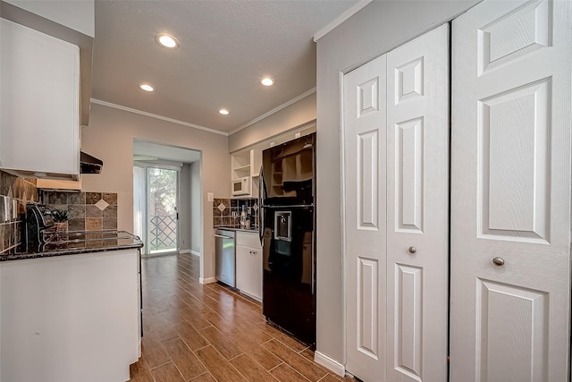 2333 Bering Dr Unit 139, Houston, TX 77057 - kitchen featuring crown molding, black fridge, white cabinetry, backsplash, and baseboards