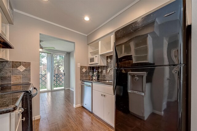 kitchen featuring dishwasher, backsplash, electric stove, black refrigerator, and white cabinets