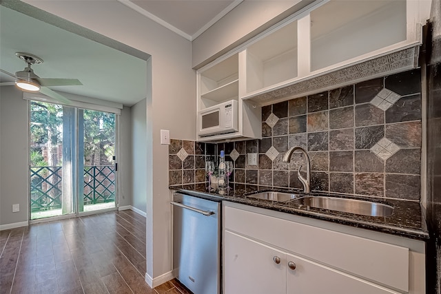 kitchen with tasteful backsplash, stainless steel dishwasher, sink, dark stone countertops, and white cabinetry