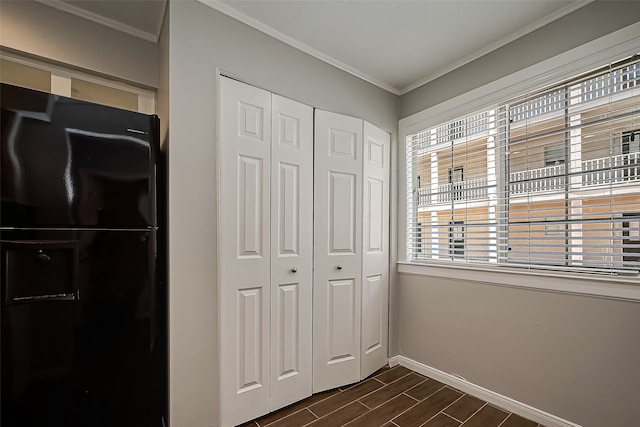 bedroom featuring black fridge, a closet, and crown molding