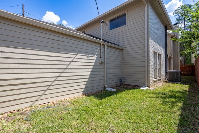 view of property exterior featuring a lawn and central AC unit