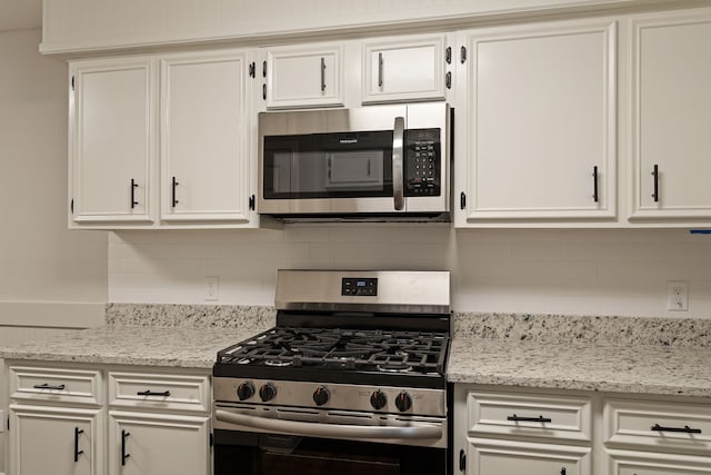 kitchen featuring white cabinetry, backsplash, and appliances with stainless steel finishes