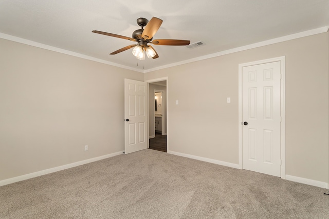 spare room featuring ornamental molding, carpet flooring, and ceiling fan