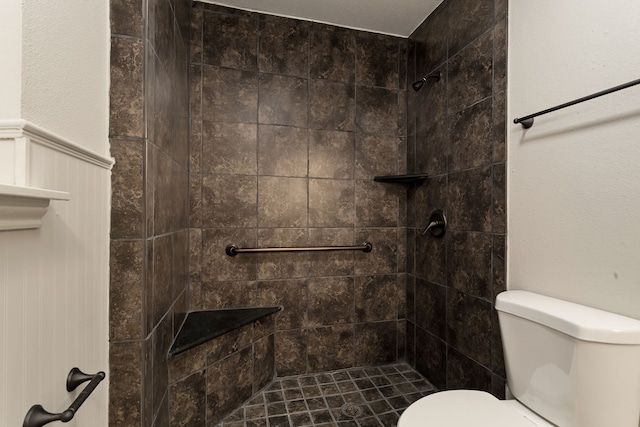 bathroom featuring a tile shower and toilet