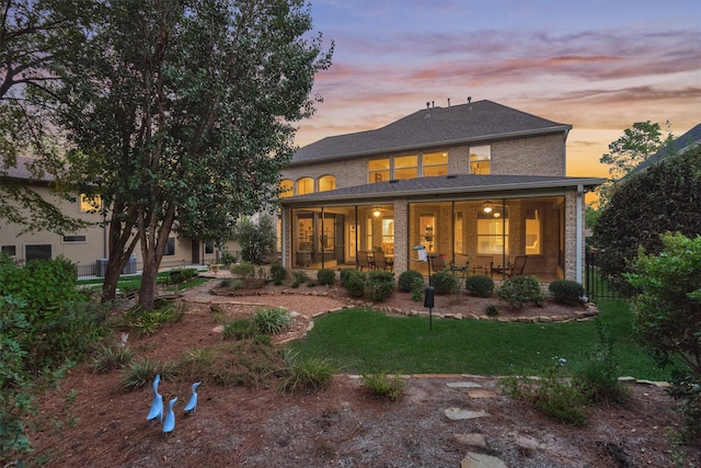 back house at dusk featuring a porch