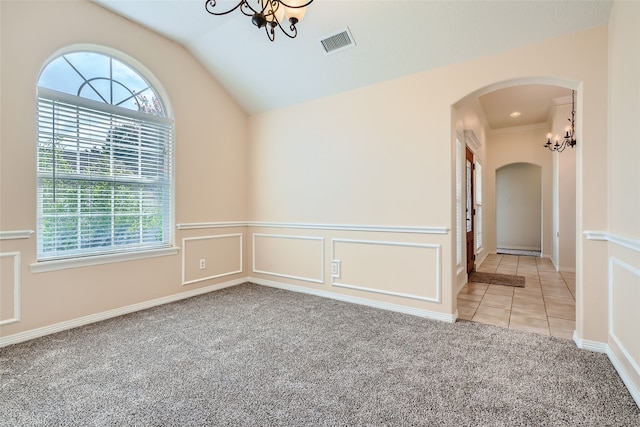 carpeted empty room with crown molding, lofted ceiling, and an inviting chandelier