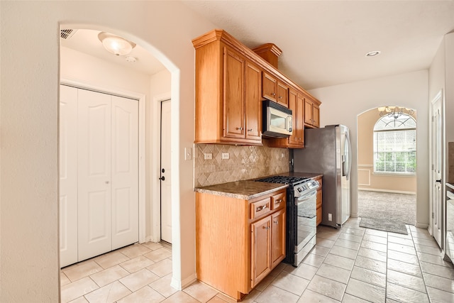 kitchen featuring appliances with stainless steel finishes, decorative backsplash, and light tile patterned floors