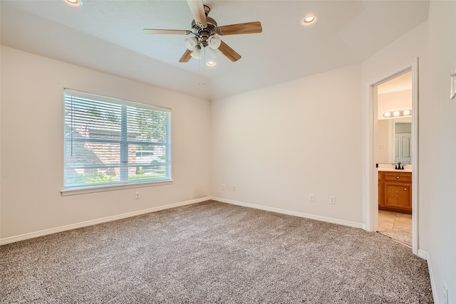 spare room featuring ceiling fan, sink, and light colored carpet