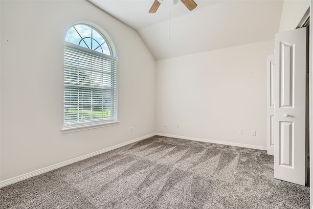 carpeted empty room featuring ceiling fan and vaulted ceiling