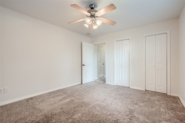 unfurnished bedroom with ceiling fan, carpet flooring, and multiple closets