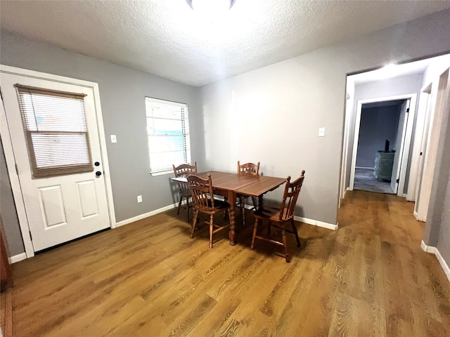 dining space with a textured ceiling and wood-type flooring