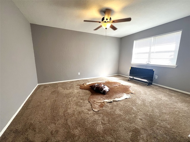 carpeted spare room with ceiling fan and a textured ceiling