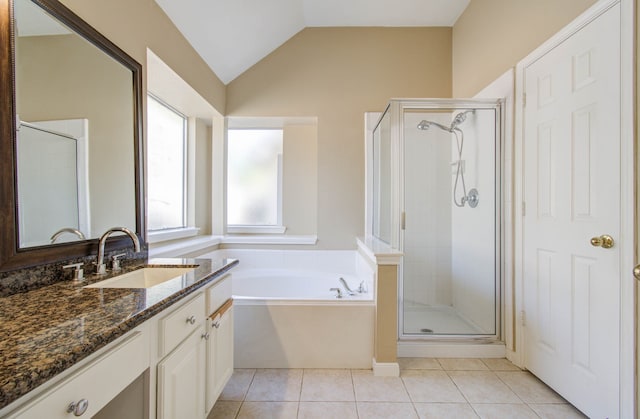 bathroom with vanity, independent shower and bath, lofted ceiling, and tile patterned flooring