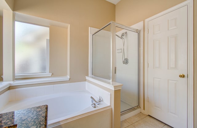 bathroom featuring tile patterned flooring and shower with separate bathtub