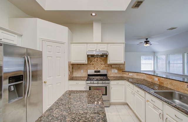 kitchen with decorative backsplash, white cabinets, and stainless steel appliances