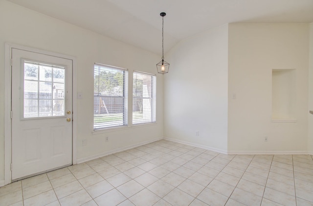 unfurnished dining area featuring light tile patterned flooring and lofted ceiling