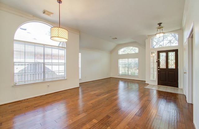 entrance foyer featuring ornamental molding, lofted ceiling, hardwood / wood-style floors, and a wealth of natural light