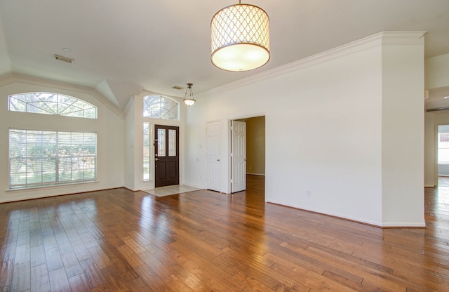 foyer featuring crown molding, hardwood / wood-style floors, and vaulted ceiling