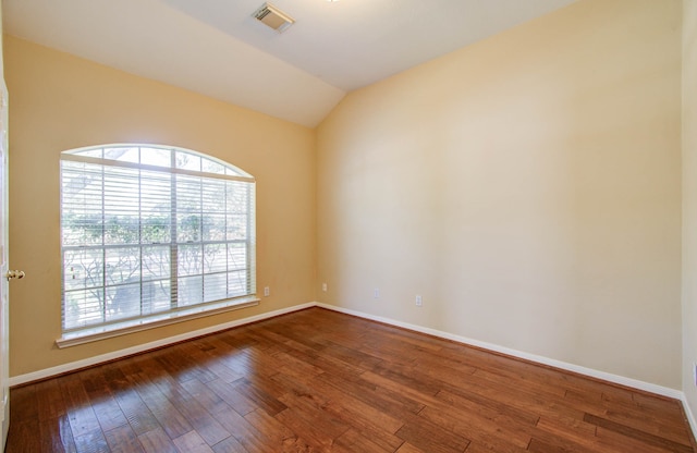 empty room featuring wood-type flooring and vaulted ceiling