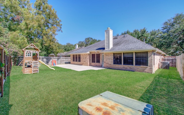 back of house featuring a patio, a playground, central AC unit, and a lawn