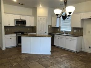 kitchen with white cabinetry, tasteful backsplash, appliances with stainless steel finishes, and a kitchen island