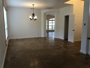 unfurnished dining area featuring an inviting chandelier