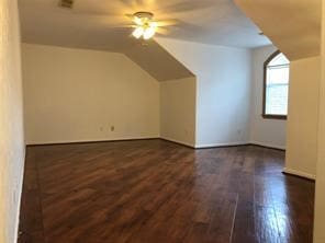 additional living space featuring lofted ceiling, dark wood-type flooring, and ceiling fan