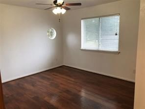 unfurnished room with dark wood-type flooring and ceiling fan