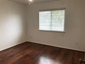 empty room with ceiling fan and dark hardwood / wood-style flooring