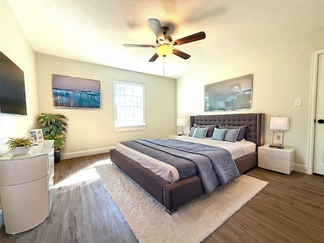 bedroom featuring a textured ceiling, wood-type flooring, and ceiling fan