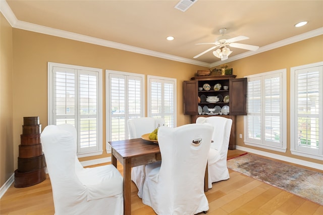 dining area featuring light wood-type flooring, ornamental molding, plenty of natural light, and ceiling fan