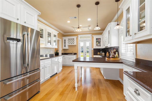 kitchen with white cabinets, hanging light fixtures, dishwashing machine, stainless steel refrigerator, and crown molding