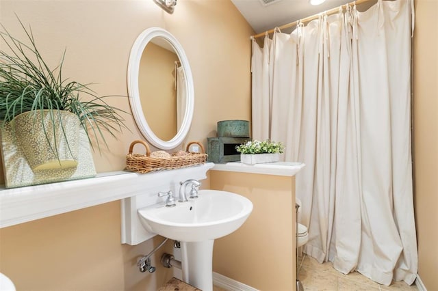 bathroom with toilet and tile patterned flooring