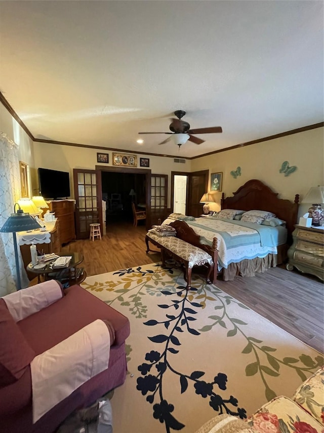 bedroom with ceiling fan, light hardwood / wood-style floors, and crown molding