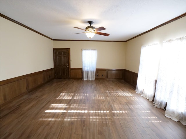 spare room with hardwood / wood-style floors, ceiling fan, ornamental molding, and a textured ceiling