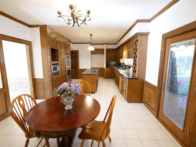 tiled dining area with crown molding, sink, and an inviting chandelier