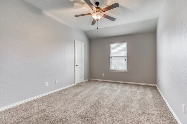 carpeted empty room featuring ceiling fan and vaulted ceiling