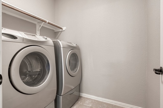 washroom featuring washer and dryer and light tile patterned flooring