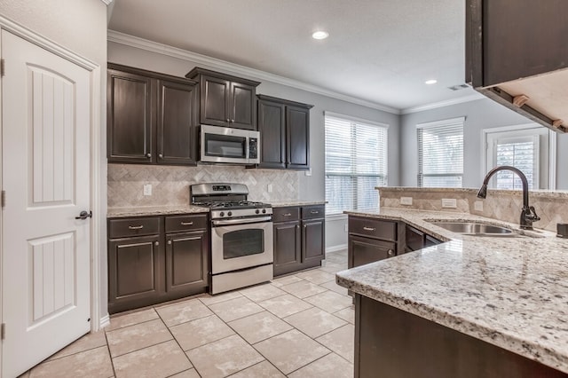 kitchen featuring dark brown cabinets, stainless steel appliances, tasteful backsplash, and sink