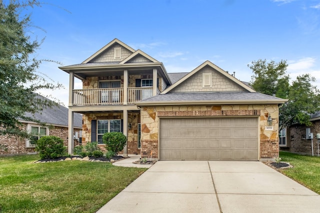 view of front of home featuring a balcony, a front yard, and a garage