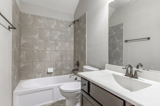 full bathroom with vanity, lofted ceiling, tiled shower / bath combo, and toilet