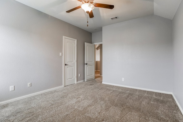 empty room featuring ceiling fan, lofted ceiling, and carpet floors