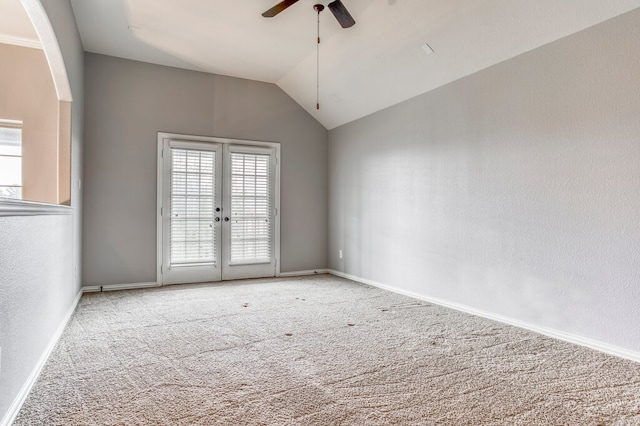 carpeted spare room with lofted ceiling, french doors, and ceiling fan