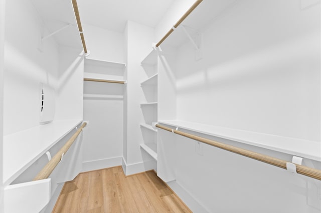 walk in closet with light hardwood / wood-style flooring