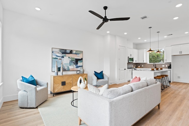 living room featuring ceiling fan and light hardwood / wood-style flooring